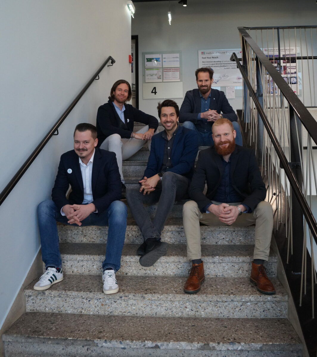 5 young men sitting on the stairs of a staircase in a University