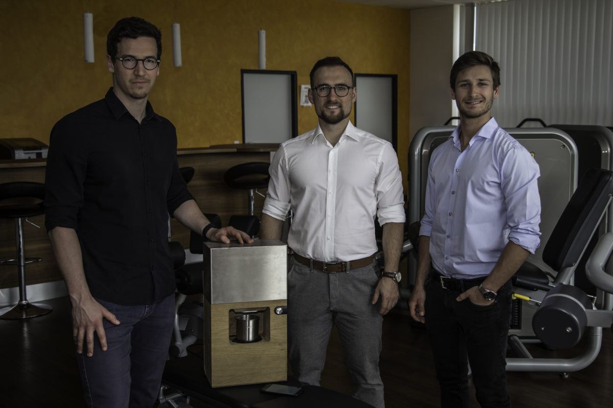 Three young men, the founders, in a gym, presenting their product.