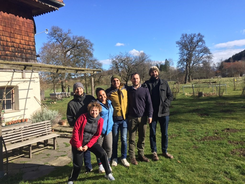 Team, 2 woman and 4 men, standing in front of a house on the country side