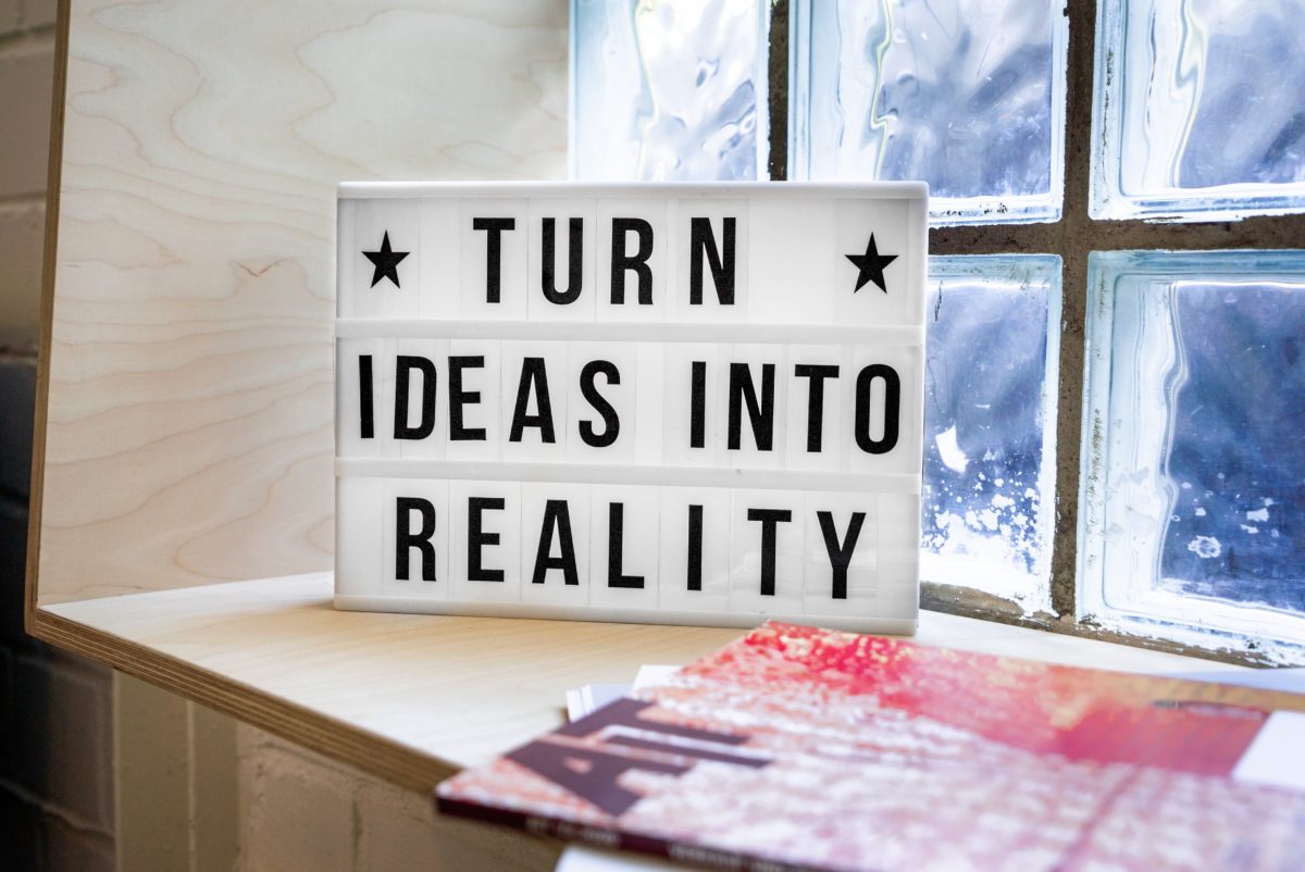 light box (text: turn ideas into reality) in front of a window, next to a magazine