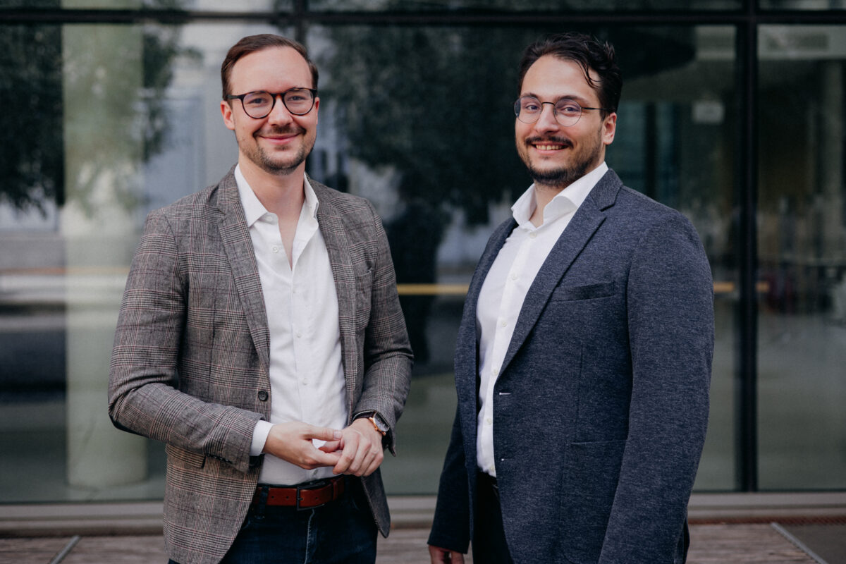 two men in jackets standing in front of a building