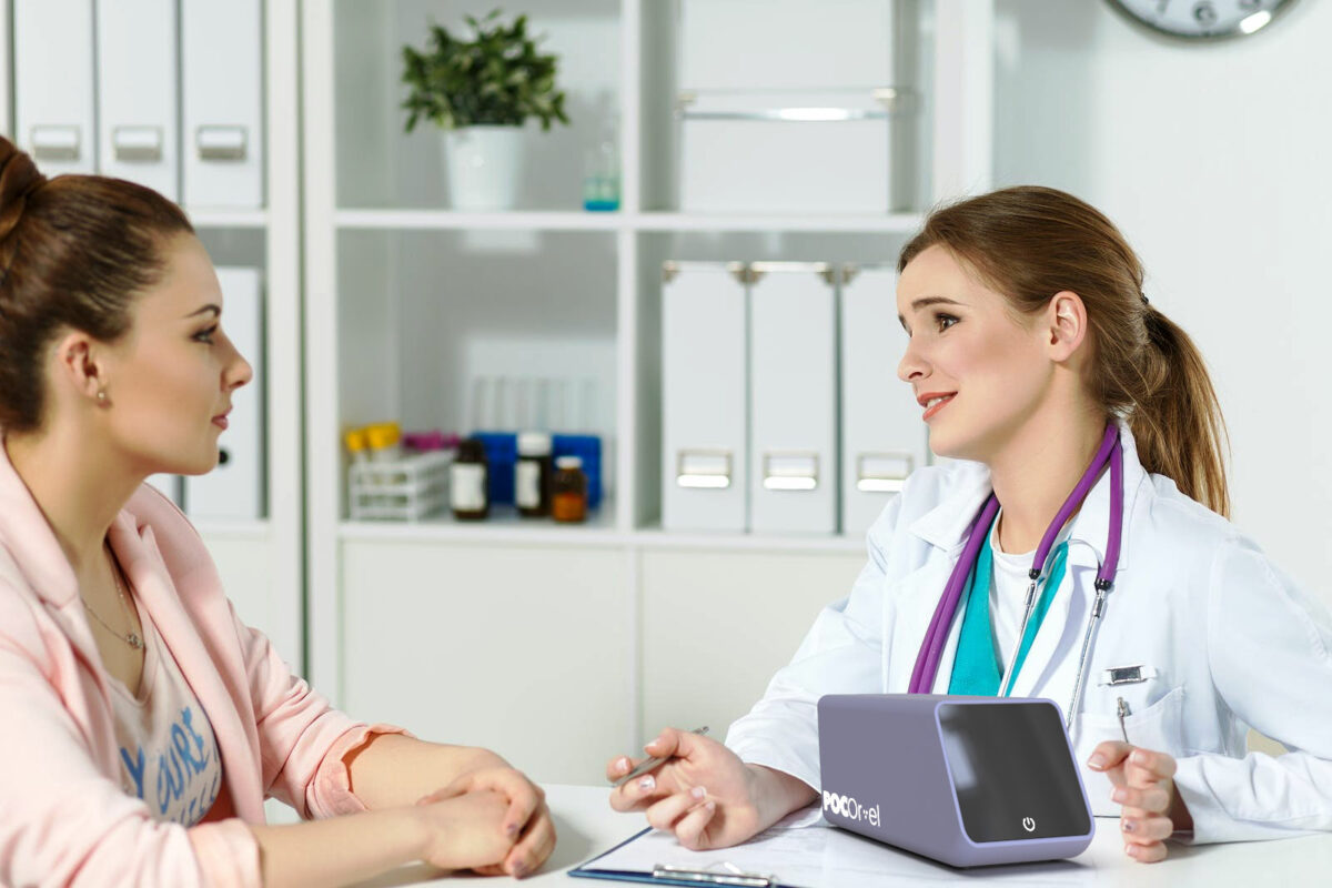 two women, female doctor and patient, sitting at a table talking. Product POCOREL on table