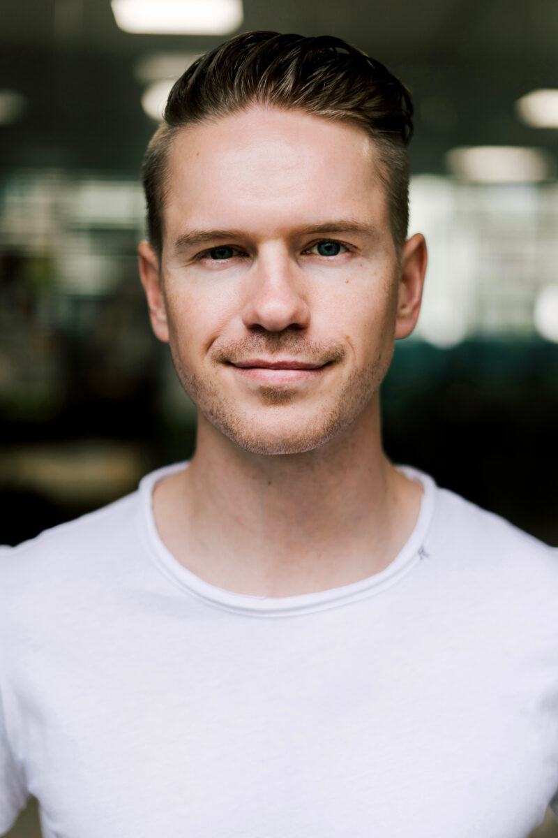 profile of young man, founder, with short blond hair, smiling