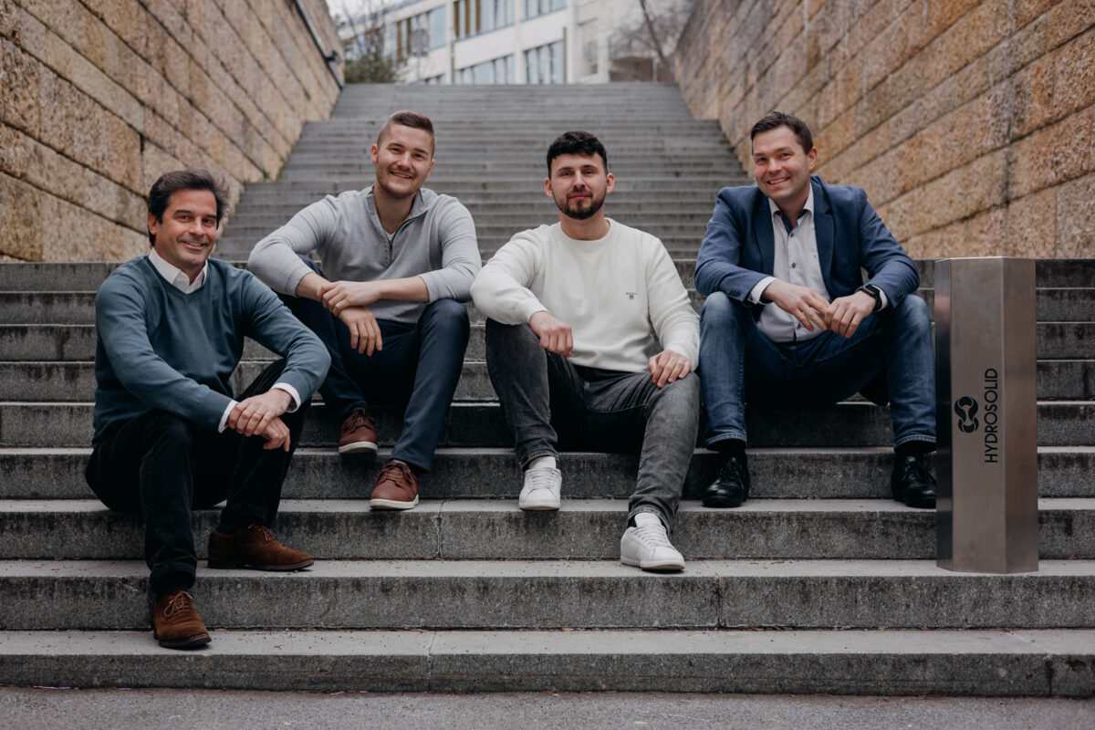 four young men sitting next to each other on a staircase