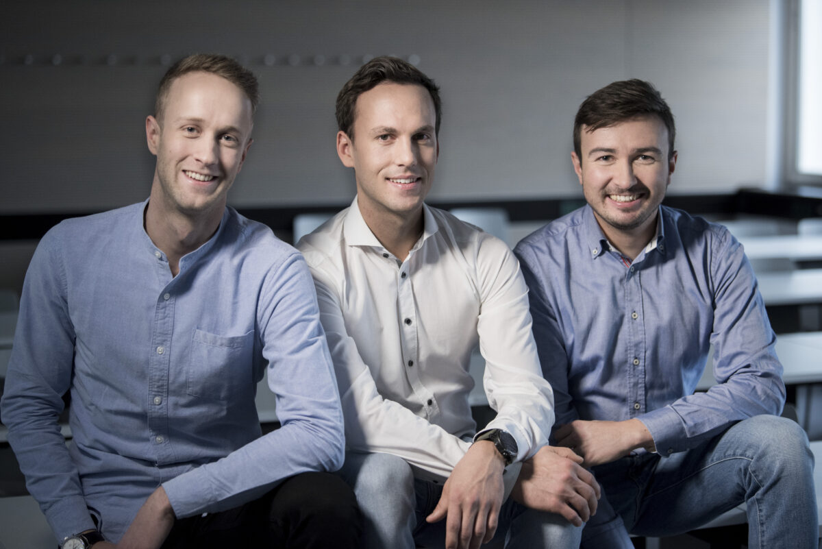 3 young men in shirts sitting on a sofa